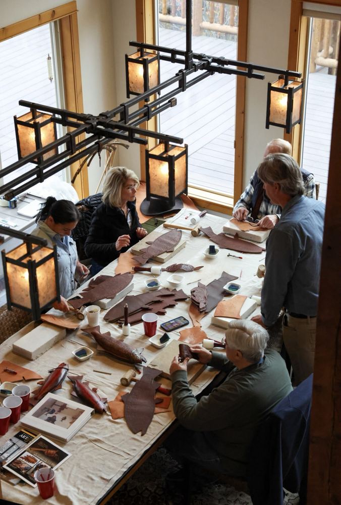 A leather workshop around a long table in a timber lodge